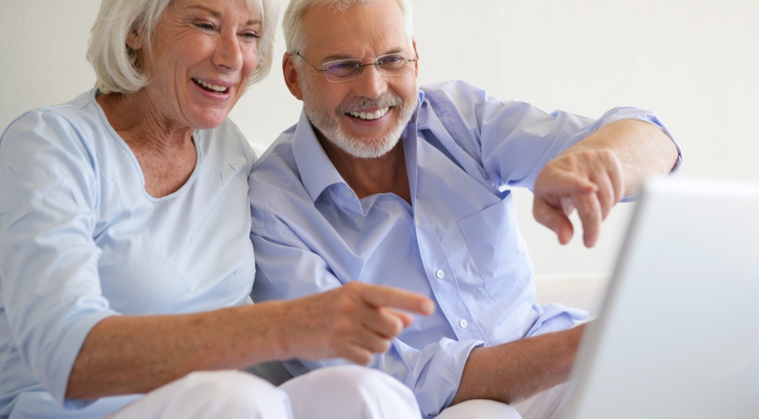 Couple de seniors souriants devant une webcam