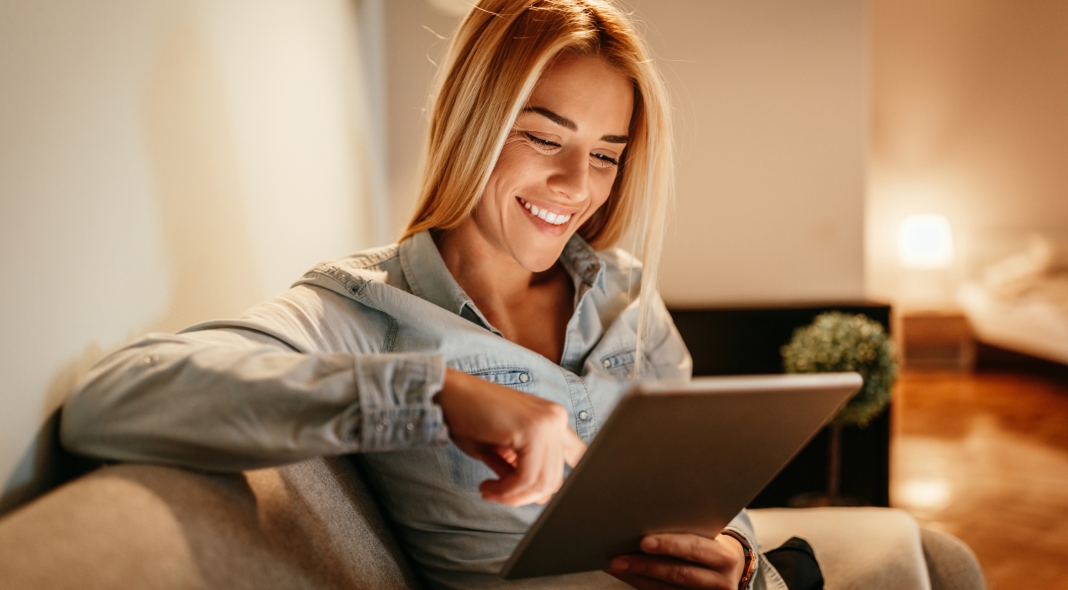 Attractive young woman holding a tablet at home