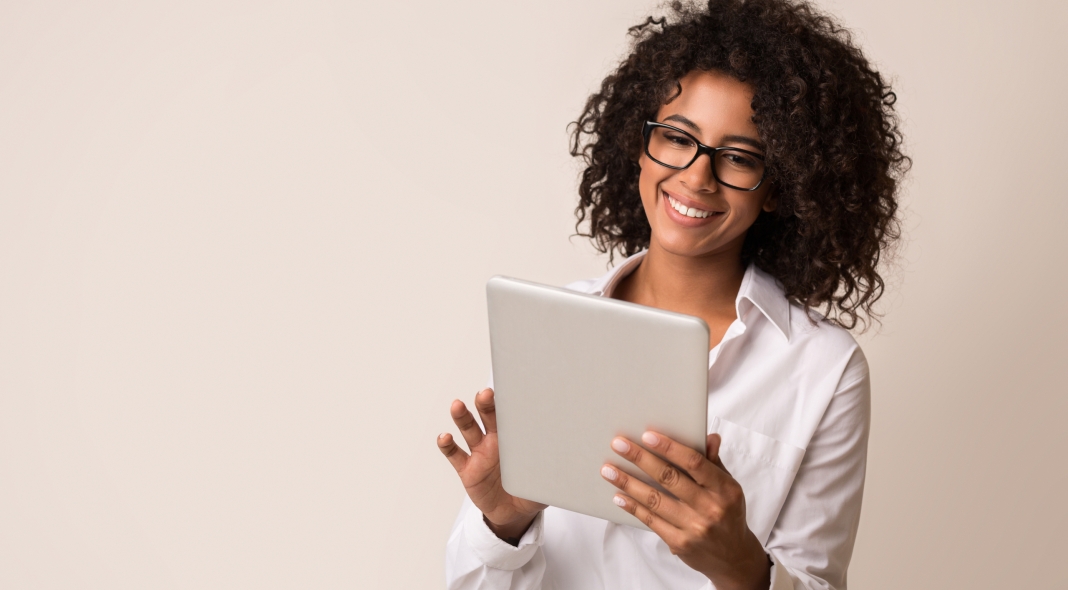 Happy african-american businesswoman using digital tablet over light background, copy space