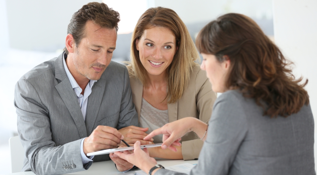 Couple signing loan grant on digital tablet